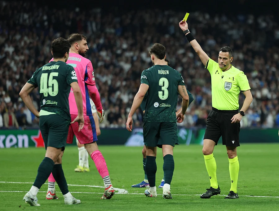 El árbitro Maurizio Mariani muestra una tarjeta amarilla a Gianluigi Donnarumma, del Manchester City - REUTERS/ VIOLETA SANTOS MOURA