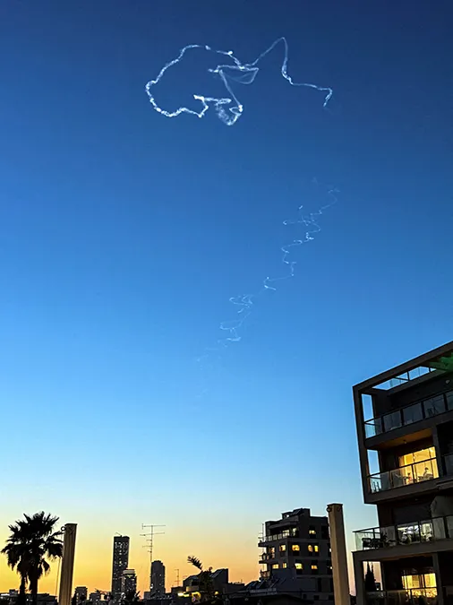 <p>Se observan estelas de condensación en el cielo tras un intento de interceptación israelí a raíz de un ataque con misiles lanzado desde Irán contra Israel, en el marco del conflicto entre Estados Unidos e Israel con Irán, visto desde Ramat Gan, Israel, el 17 de marzo de 2026 - Fotografía tomada con un teléfono móvil. REUTERS/Nir Elia</p>