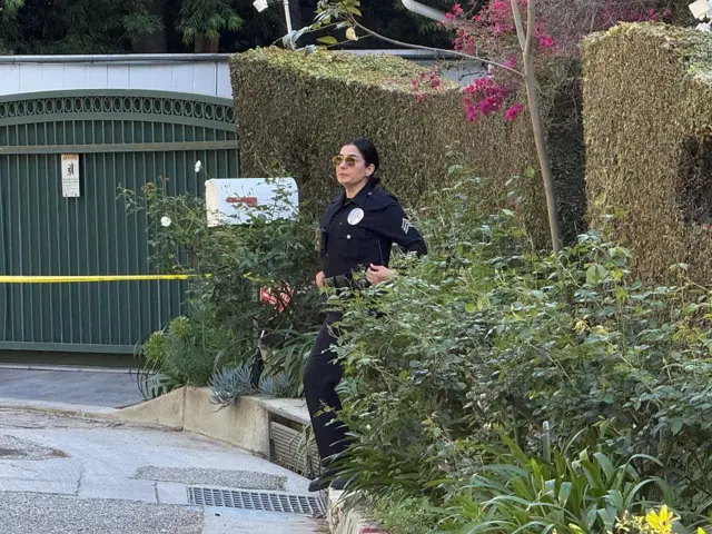 Una policía en una puerta de la casa de Rihanna