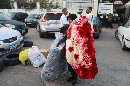Una familia libanesa descarga sus pertenencias tras regresar a su hogar por el alto el fuego. 