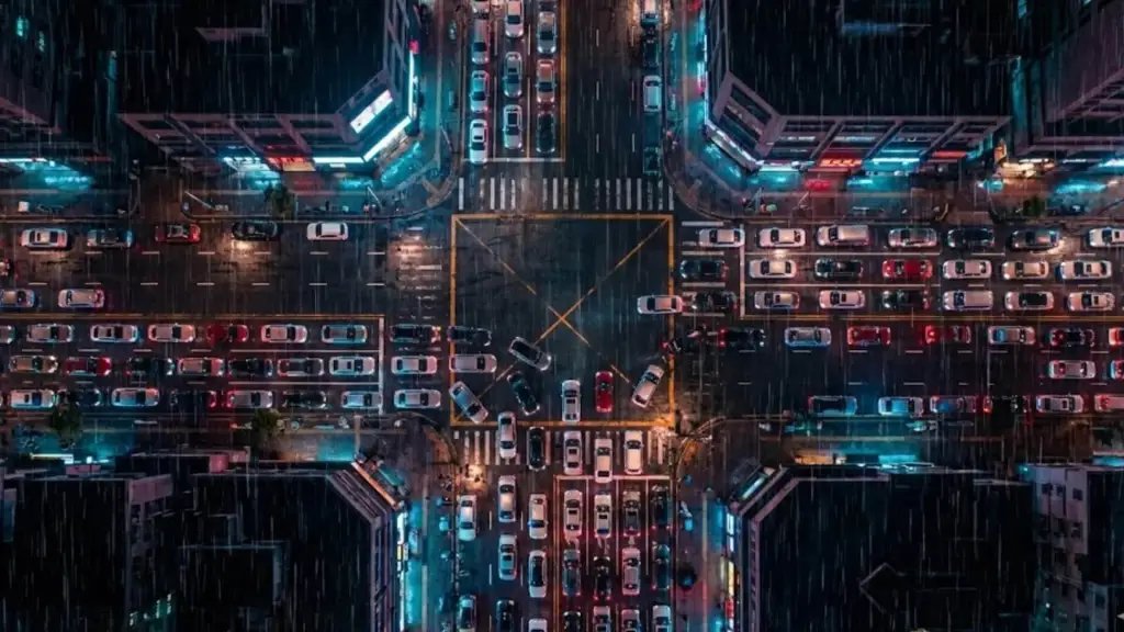 Recreación artística que muestra una vista aérea cenital de un complejo cruce urbano en una ciudad densa por la noche. Foto: Nano Banana / Scruzcampillo.