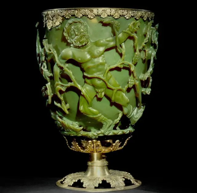 Copa para beber; de vidrio verde; cubierta con diversas escenas que representan la muerte del rey Licurgo; el borde está adornado con una banda de plata dorada con motivos de hojas, además de una base de plata dorada con hojas de vid caladas.