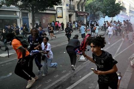 Un grupo de seguidores del PSG corre para ponerse a salvo de los gases lacrimógenos lanzados por los antidisturbios
