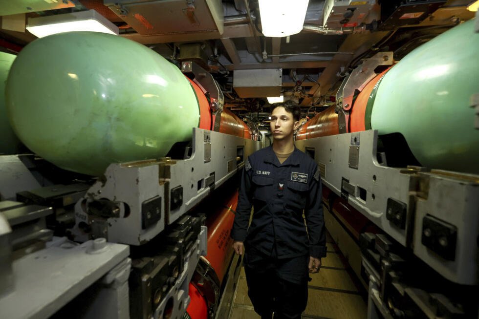 El oficial de la Armada Devin Simpson posa para una fotografía junto a unos torpedos MK 48 a bordo del submarino de ataque rápido de la clase Virginia USS Minnesota, tras el atraque del buque en el HMAS Stirling, en Rockingham (Australia Occidental), durante una visita el 26 de febrero de 2025.