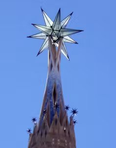 An illuminated star sits at the top of a pointed tower.