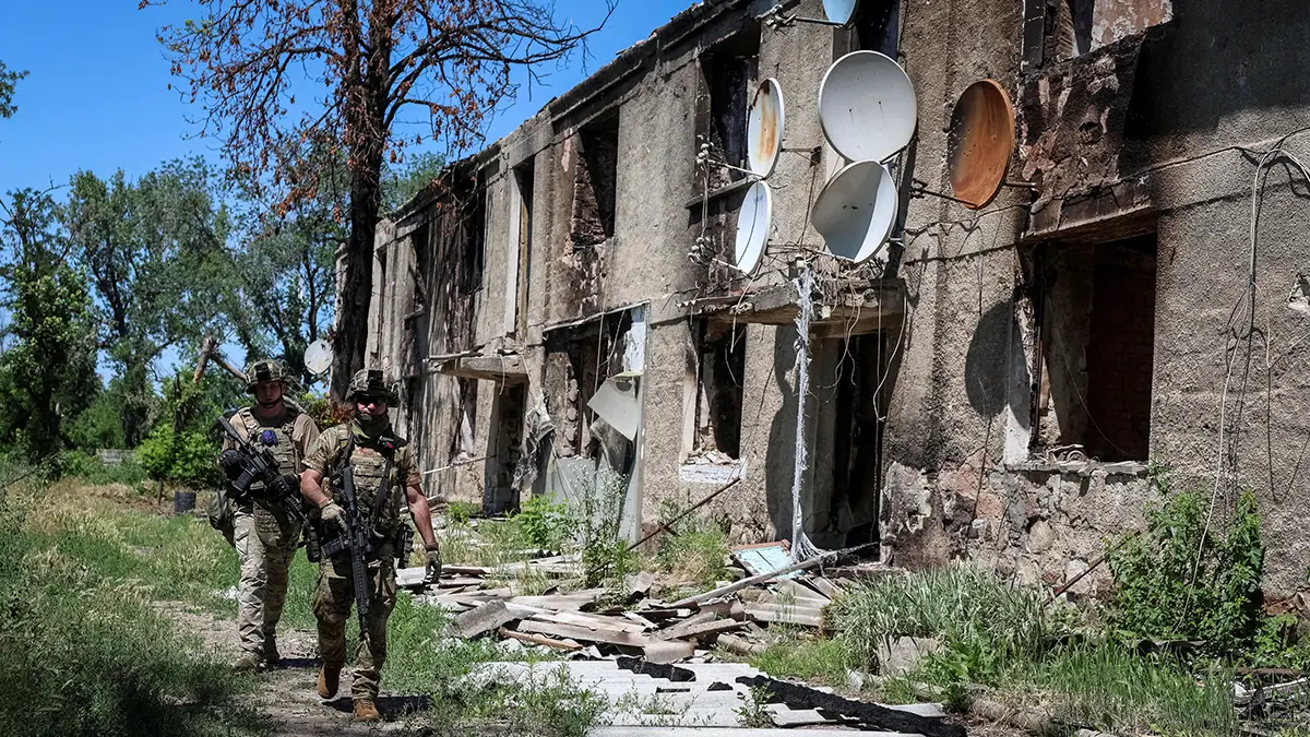 Militares de la Brigada Consolidada Khyzhak del Departamento de Policía de Patrulla de Ucrania caminan cerca de un edificio de apartamentos destruido mientras participan en una misión para proteger una carretera de drones rusos entre las ciudades de primera línea de Druzhkivka y Kostiantynivka, en medio del ataque de Rusia a Ucrania, en la región de Donetsk - REUTERS/ ANATOLII STEPANOV