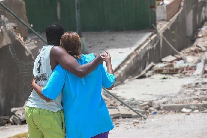 Dos personas se abrazan, tras observar los estragos de los terremotos