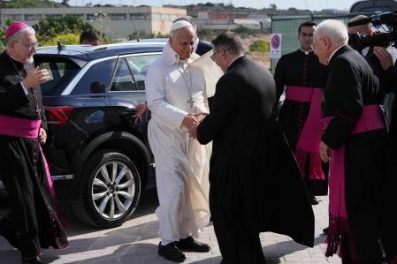 El papa León XIV es recibido por el párroco de Lampedusa a su llegada al aeropuerto de Lampedusa, Sicilia.