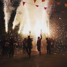 Un grupo de personas encendiendo fuegos artificiales por la noche